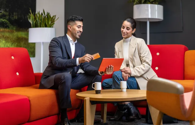 Man and woman sitting on sofas in Circle K office discussing the Circle K card