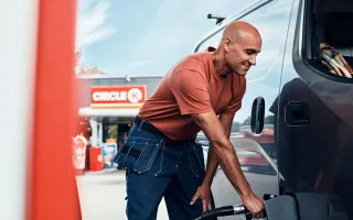 A person filling a car with a gas pump at a Circle K station