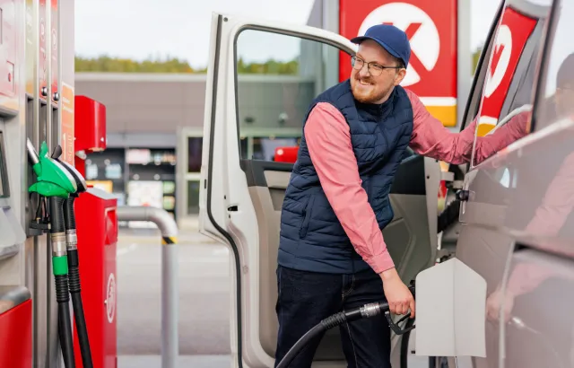 Man smiling while fueling his van at a Circle K station