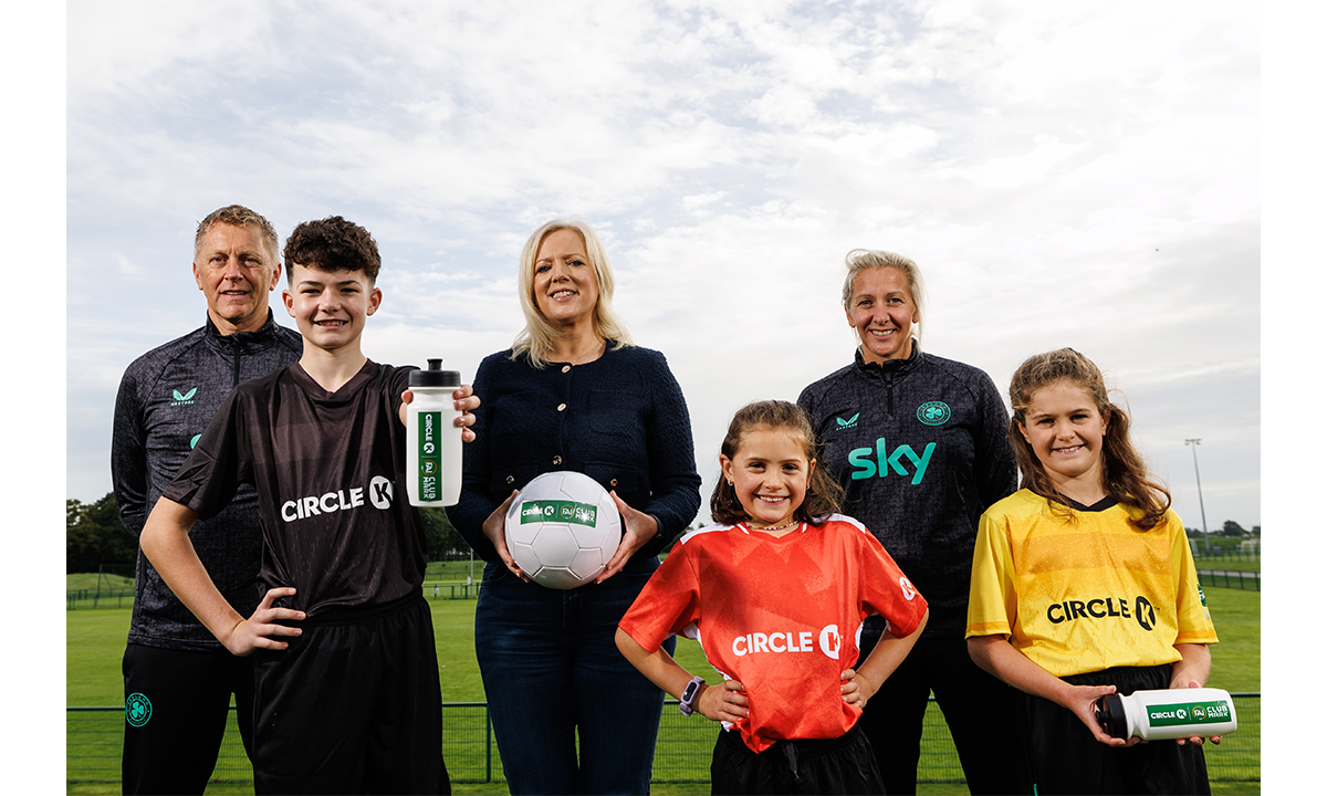 Photo of three representatives from Circle K and FAI, alongside three children wearing grassroots uniforms